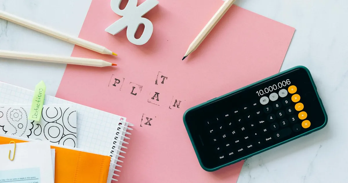 Flat lay showing tax planning tools including a calculator, pencils, and stationery items.