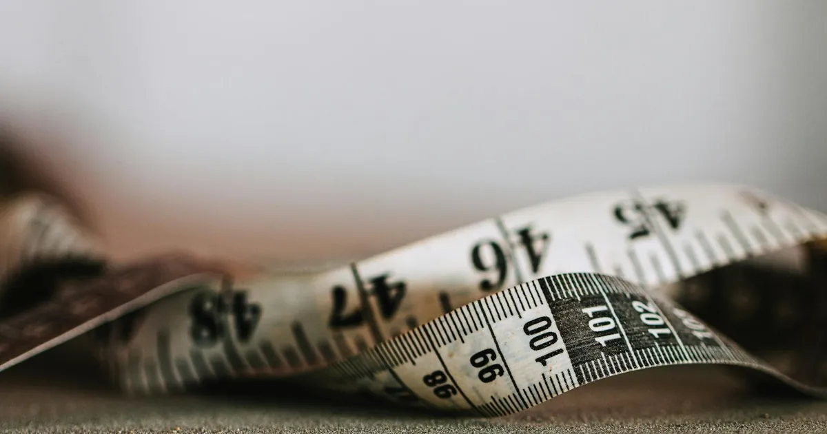 Artistic shallow focus image of a measuring tape showing numbers and units.