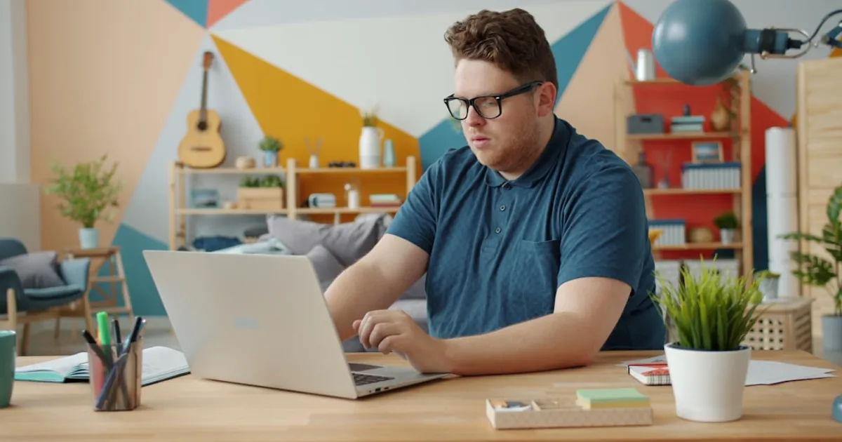 Man working on a laptop at a desk.