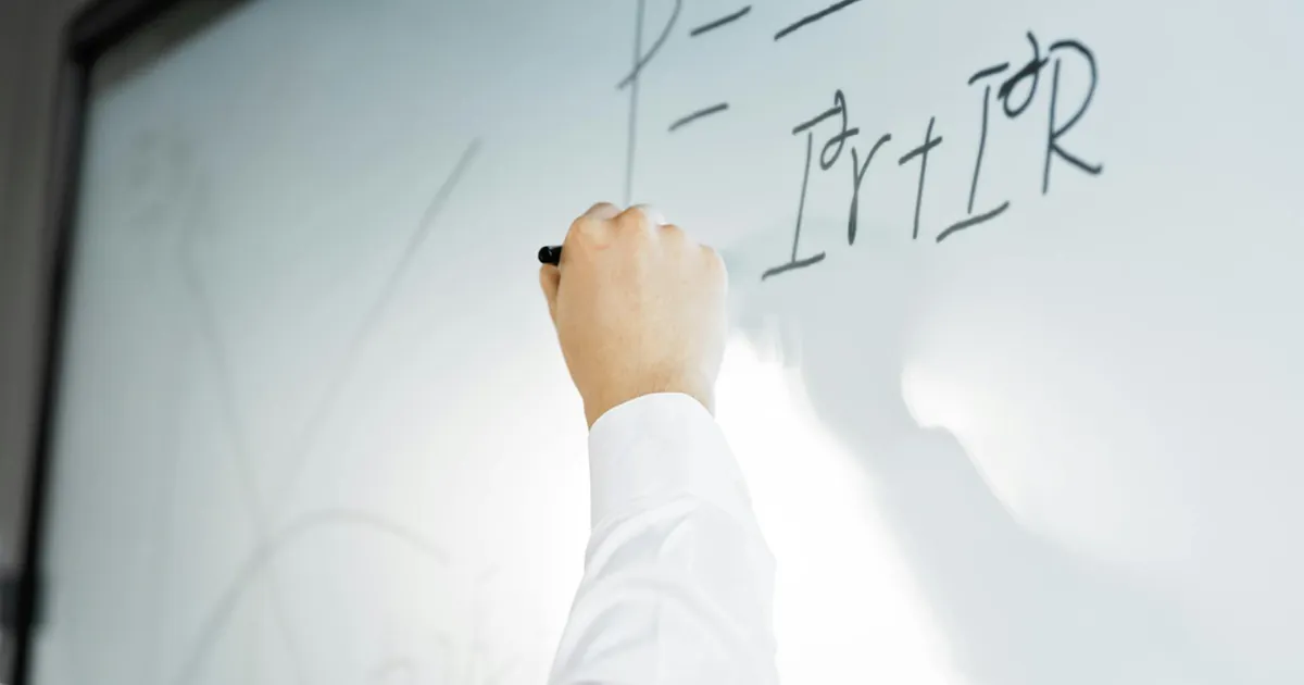 Close-up of a hand writing a formula on a whiteboard in a professional setting. Close-up of a hand writing a formula on a whiteboard in a professional setting.