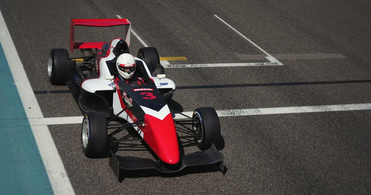 Dynamic image of a race car on a track in Abu Dhabi, showcasing speed and precision.