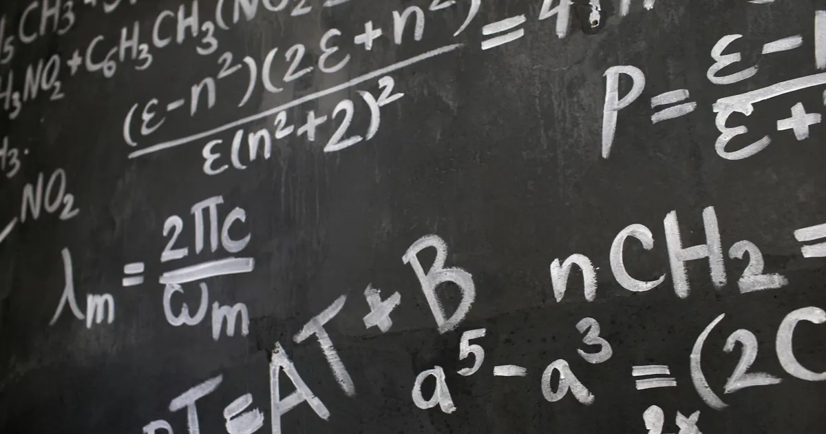 Close-up view of a blackboard filled with complex mathematical equations and formulas.