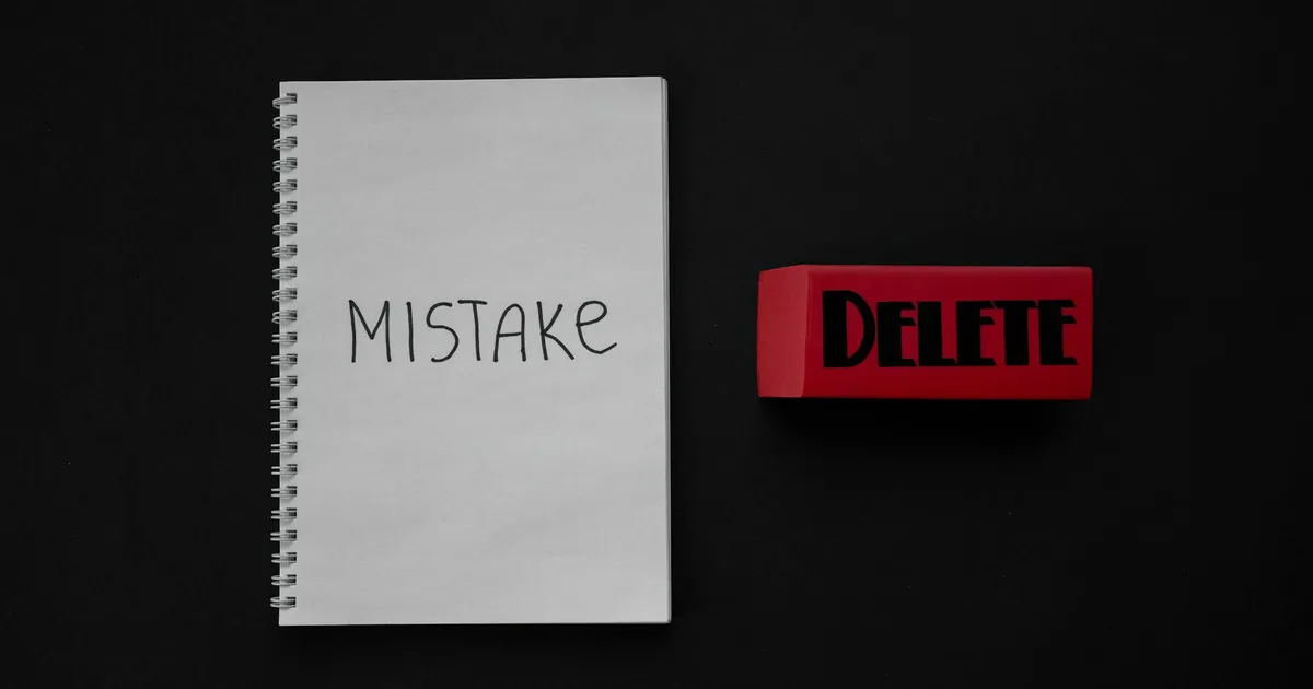 Notebook labeled 'Mistake' next to a red delete eraser on a dark background.