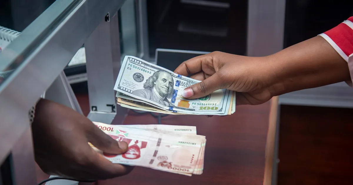 Hands exchanging US and local currency at a bank counter, signifying international finance.