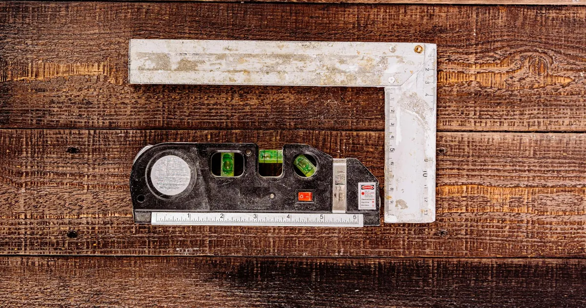 Top view of carpenter's measuring tools on rustic wooden surface, ideal for construction concepts.