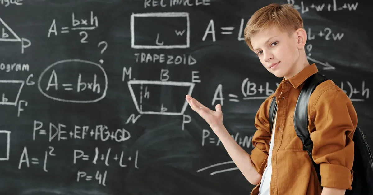 A young student confidently demonstrating geometric formulas on a classroom blackboard. A young student confidently demonstrating geometric formulas on a classroom blackboard.