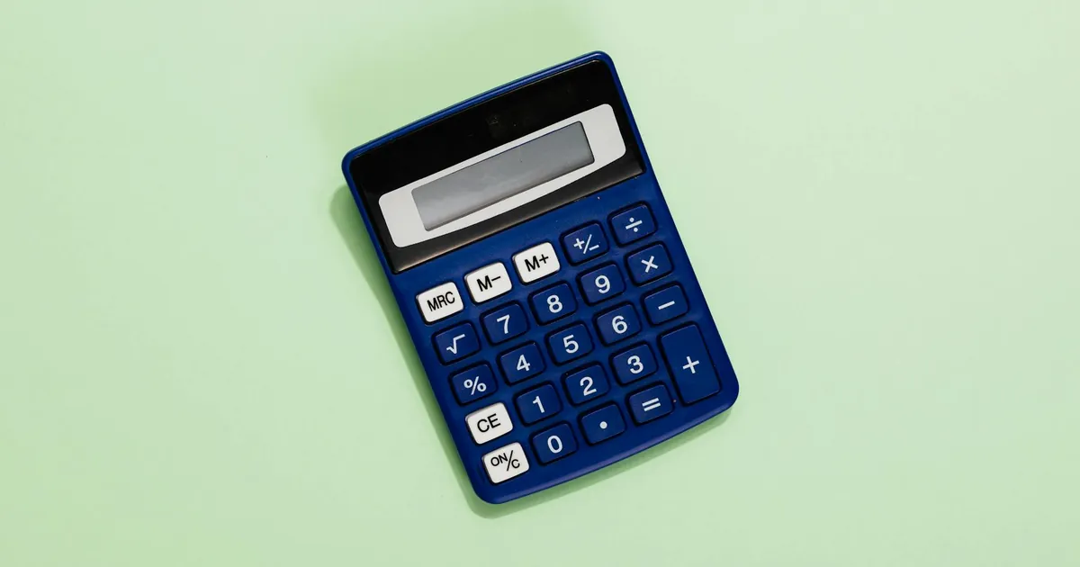 A blue calculator placed on a light green background. Ideal for financial and educational themes.