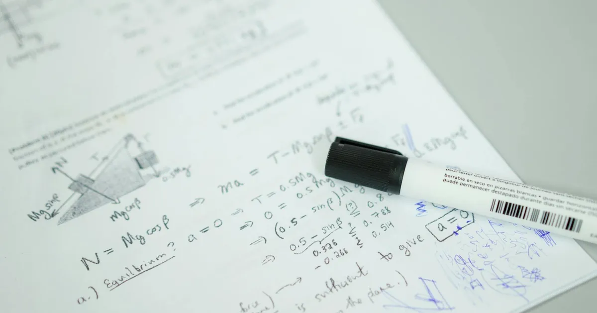 Close-up showing mathematical formulas and a marker on bond paper, ideal for education themes.