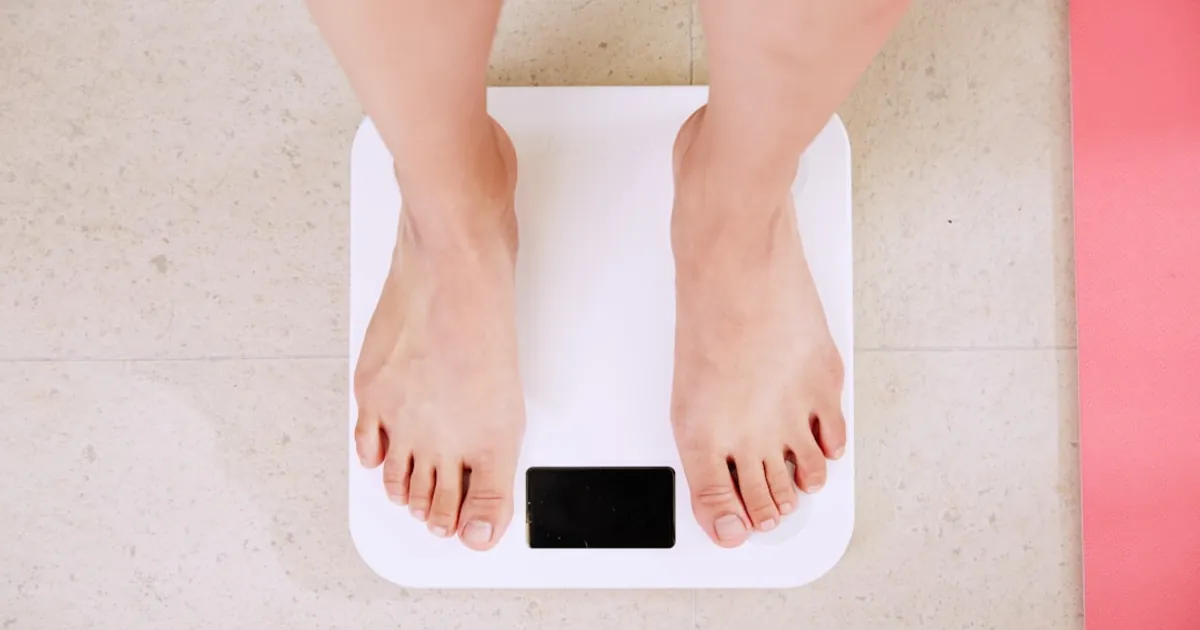 person standing on white digital bathroom scale